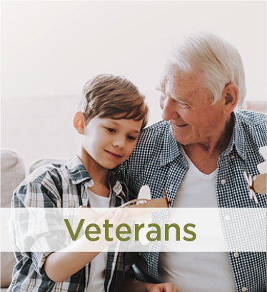 Elderly Man and child playing with toy airplanes. Labeled Veterans Covenant Care